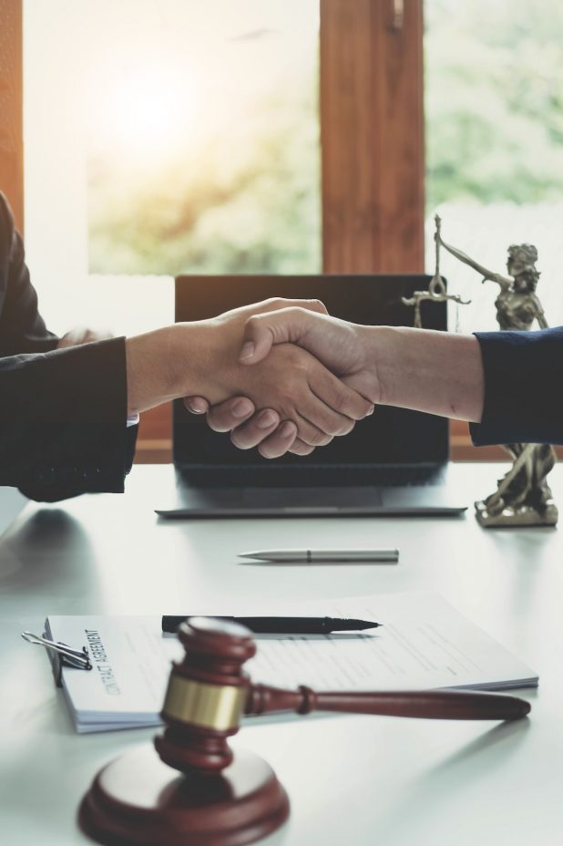 Businessman shaking hands to seal a deal with his partner lawyers or attorneys discussing a contract